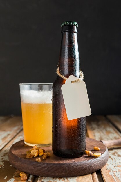 Front view of beer glass bottle with tag and nuts