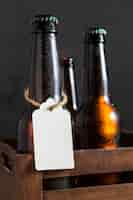 Free photo front view of beer glass bottles in crate with tag