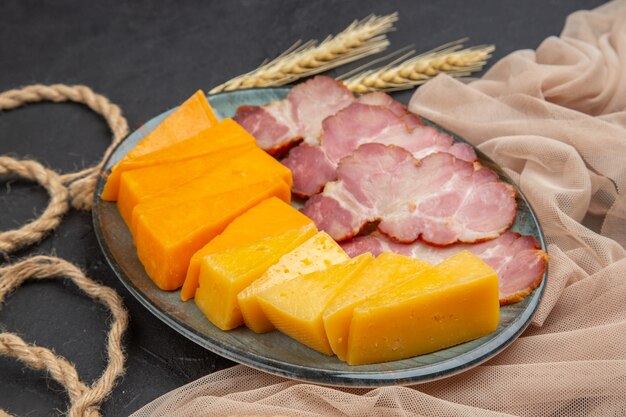 Front view of best delicious snacks for wine on a towel on a dark table