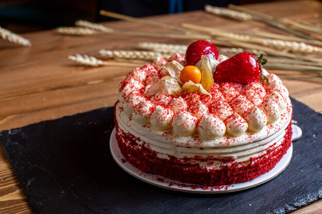 A front view birthday cake decorated with cream strawberries round sweet birthday celebration