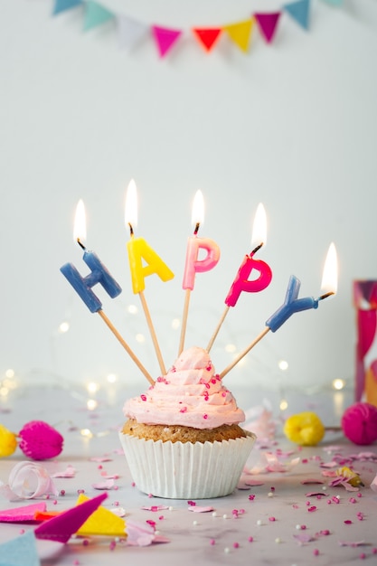 Front view of birthday cupcake with lit candles