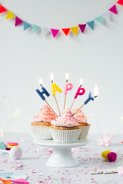 Front view of birthday cupcakes with lit candles