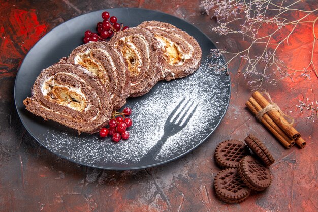 Front view of biscuit rolls with cookies on dark surface