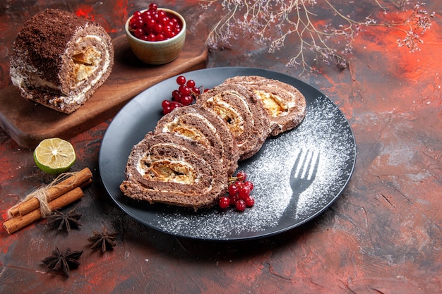 Free photo front view of biscuit rolls with red fruits on dark surface