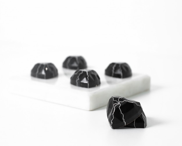 전면보기 검은 밝은 돌은 흰색 바닥에 약간 설계되었습니다.