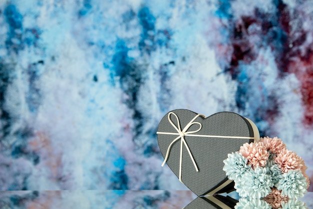 Vista frontale di fiori colorati scatola cuore nero su sfondo astratto