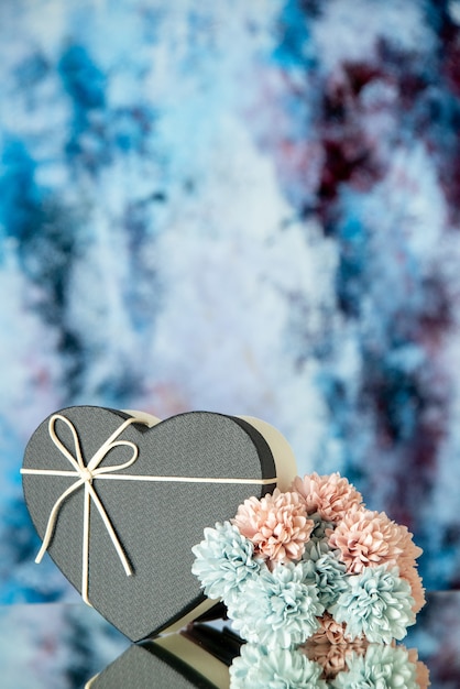 Free photo front view of black heart box colored flowers on abstract background