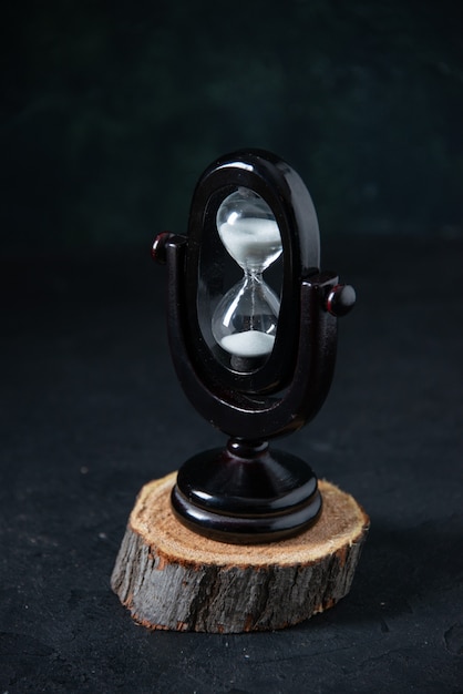 Front view of black hourglass on dark surface