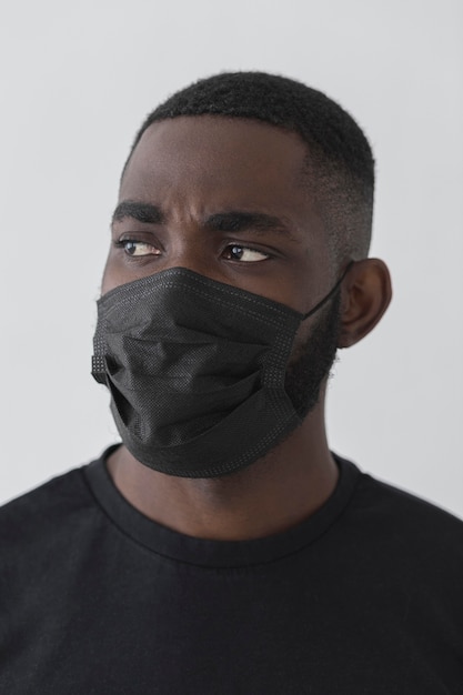 Front view black person wearing mask and looking away