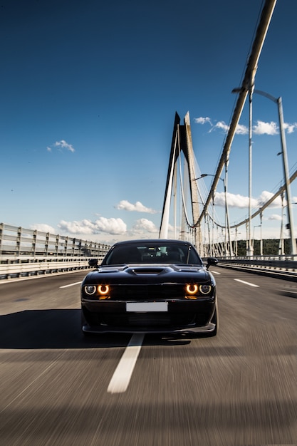 Front view of a black sedan sport car on the bridge.