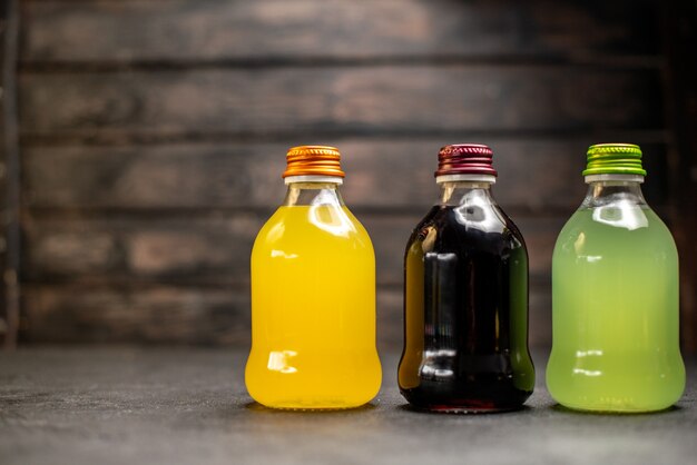 Front view black yellow and green juice in bottles