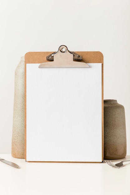 Front view of blank menu with cutlery and vase