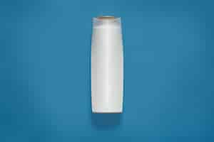 Free photo front view of blank white plastic cosmetics bottle isolated on blue studio, empty cosmetic container, mock up and copy space for advertisment or promotional text. beuity concept.