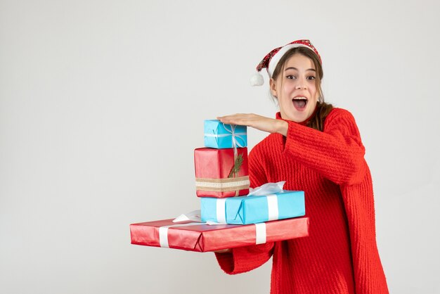 Вид спереди блаженная девушка в шляпе санта-клауса держит ее рождественский подарок