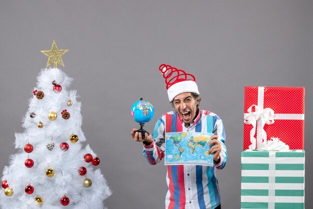 Front view blissful man holding world map and globe