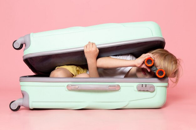 A front view blonde boy inside white bag on the pink floor