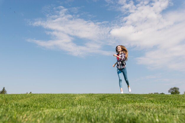 Front view blonde girl running on grass