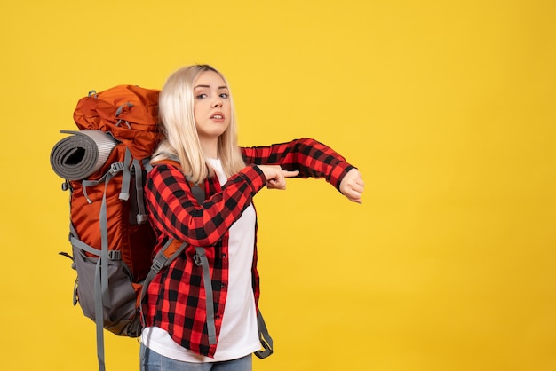 Бесплатное фото Блондинка вид спереди с ее рюкзаком, спрашивая время