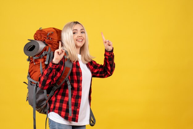 Front view blonde girl with her backpack pointing with fingers up