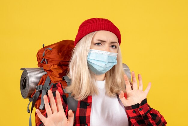 Front view blonde girl with her backpack wearing mask