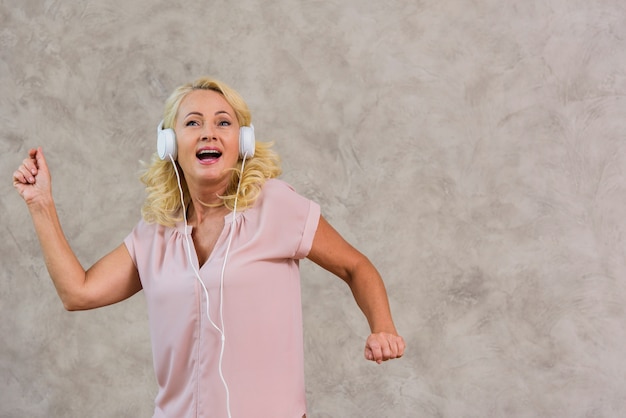 Front view blonde lady listening to music on headphone set