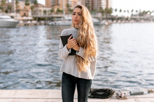 Front view blonde woman holding a book