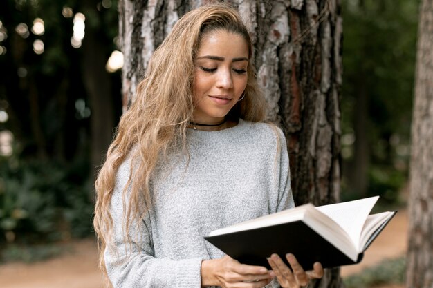 Front view blonde woman reading outside