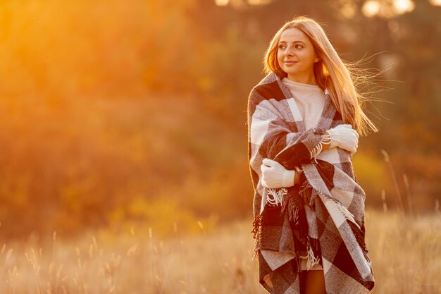 Front view blonde woman staying outside with copy space