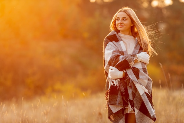 Front view blonde woman staying outside with copy space