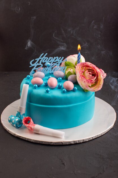 A front view blue birthday cake with flower on top cake color