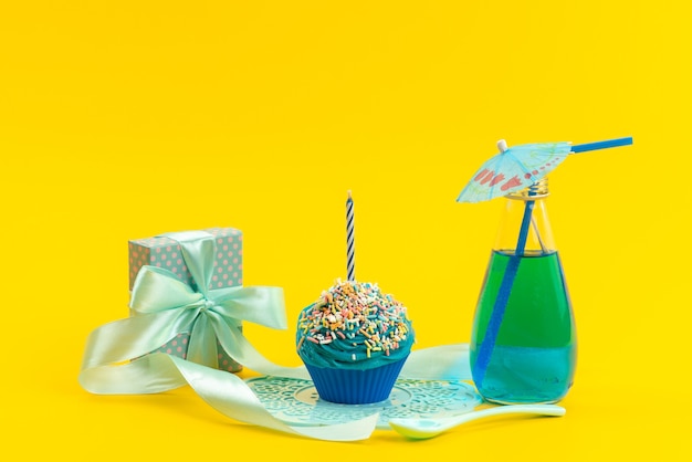 Вид спереди синий торт со свечой, маленькая подарочная коробка и напиток на желтом, сладком цвете