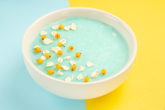 青黄色のテーブルミルク色シリアルのプレート内の正面図青いアイスデザート