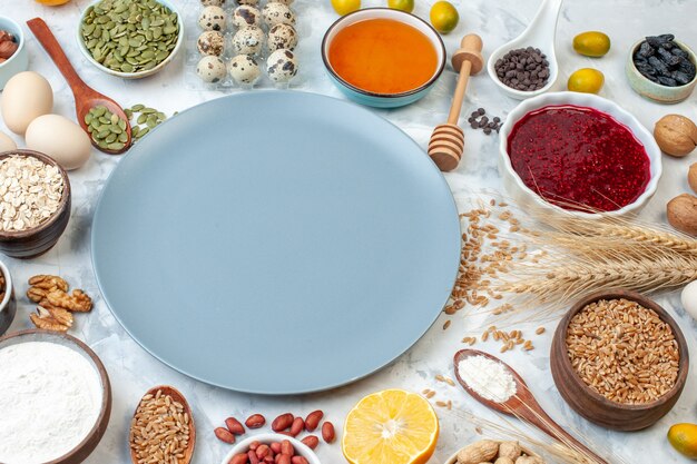 Front view blue plate with flour jelly eggs and different nuts on white background dough fruit cake sugar photo color pie nut sweet