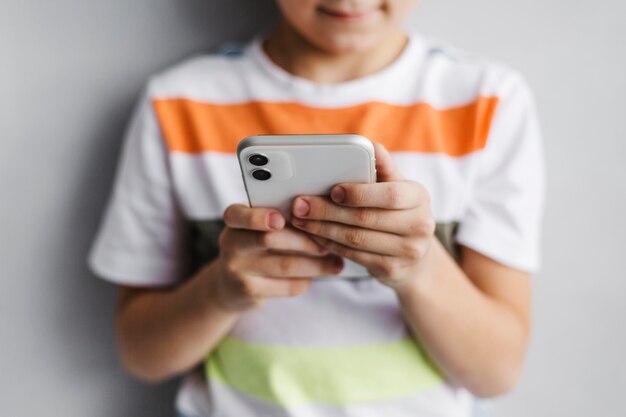 Вид спереди размытый ребенок с помощью мобильного телефона
