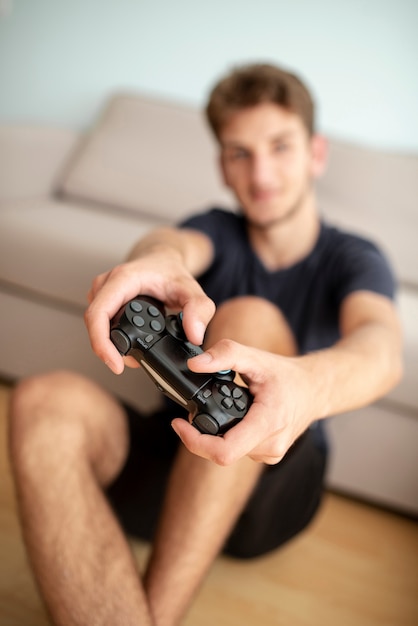 Foto gratuita vista frontale offuscata ragazzo con controller di gioco