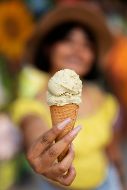 Front view blurry hispanic woman holding ice cream
