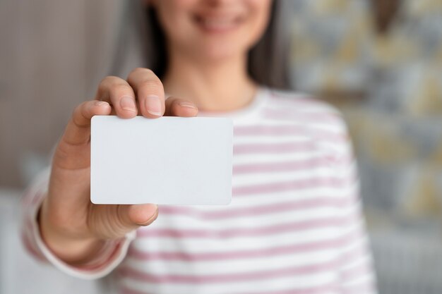 Front view blurry woman holding business card