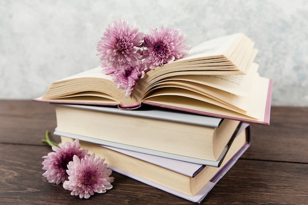 Front view of books and flowers on wooden table