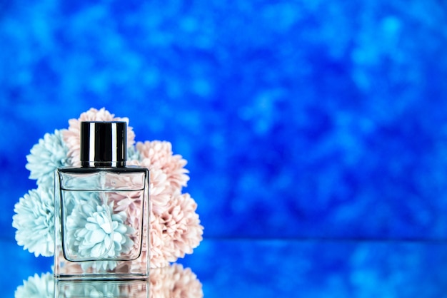 無料写真 空きスペースと青い背景の上の香水の花の正面図のボトル