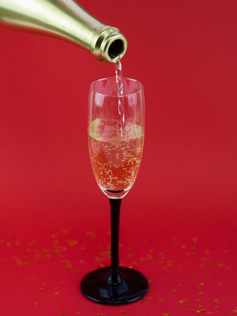 Front view of bottle pouring champagne in glass