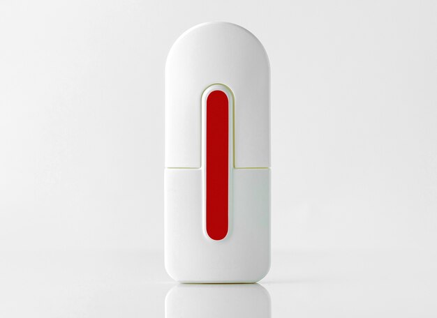 A front view bottle with fragrance white and red designed on the white wall