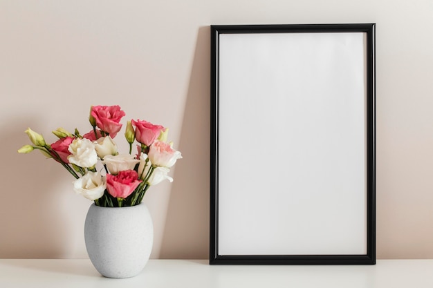 Front view bouquet of roses in a vase with empty frame