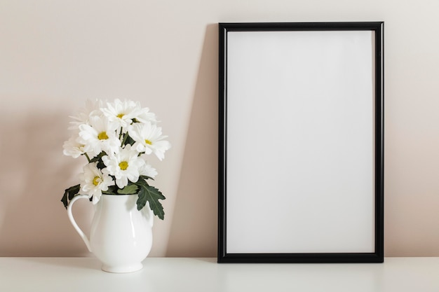 Front view bouquet of white flowers in a vase with empty frame