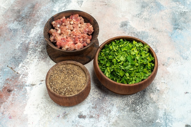 裸の背景に黒胡椒の緑の肉と正面のボウル 無料写真