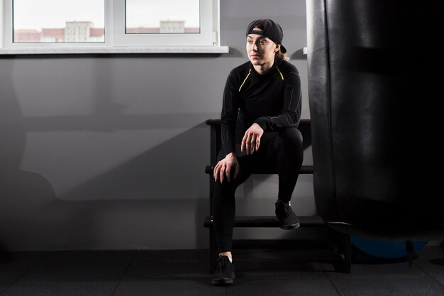 Front view of boxer trainer posing in gym