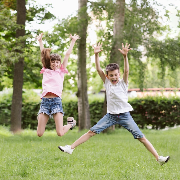 Free photo front view boy and girl jumping