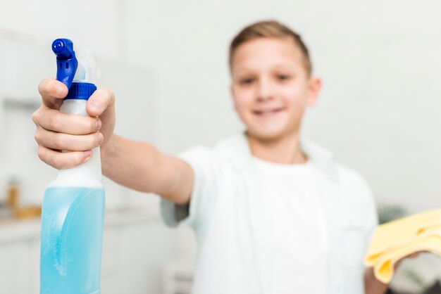 Front view of boy holding cleaning product