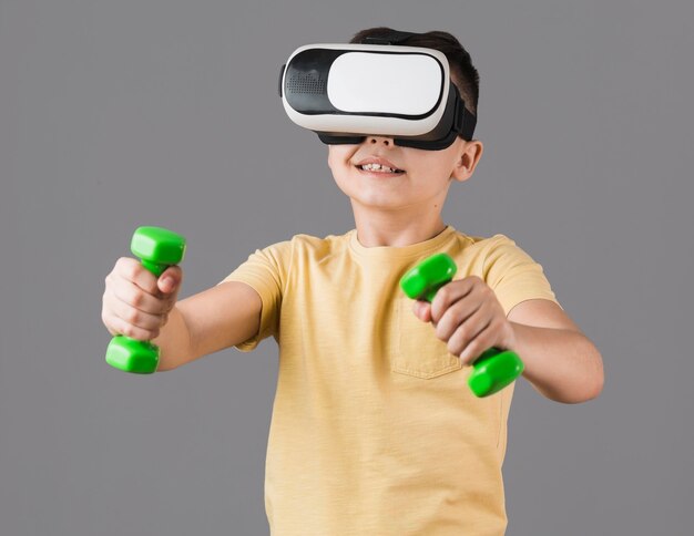 Front view of boy holding weights while wearing virtual reality headset