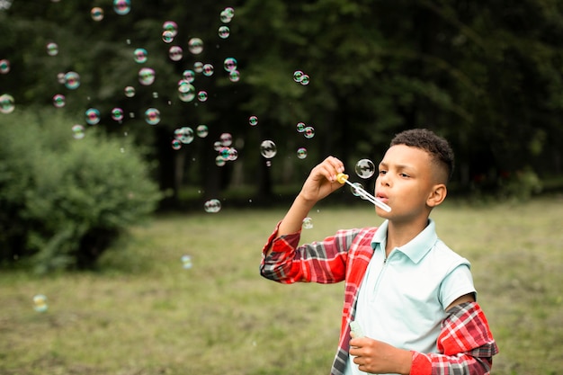 Free photo front view of boy making soap bubbles