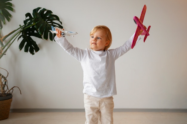 Front view boy playing with airplanes